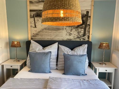 Schlafzimmer mit einem Bett mit blauen und weißen Kissen in der Unterkunft Ferienhaus Grosses Meer mit Boot in Südbrookmerland