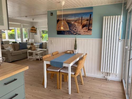 eine Küche und ein Wohnzimmer mit einem Tisch und Stühlen in der Unterkunft Ferienhaus Grosses Meer mit Boot in Südbrookmerland