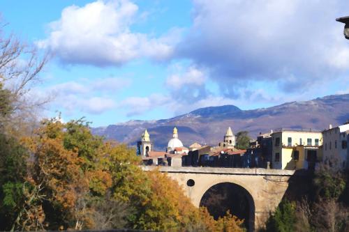 a city with a bridge and mountains in the background at B&b Sant'Agata in SantʼAgata deʼ Goti