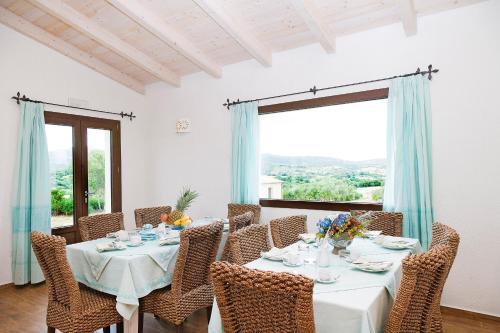 a dining room with a table and chairs and a window at B&B Terra e Smeralda in Arzachena