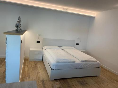 a bedroom with a bed and a white wall at Chalet dal Grant in Livigno
