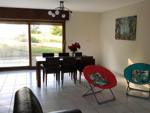 une salle à manger avec une table et des chaises dans l'établissement Fermette 3ch - 6p au pays du coquelicot by La Source d'OrFée, à Courcelette