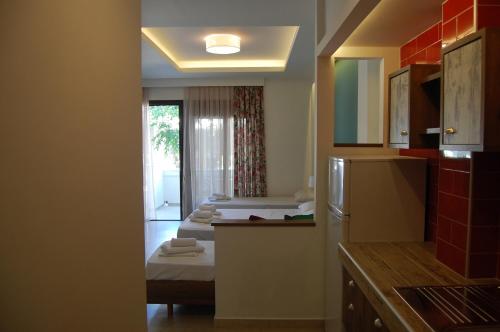 a kitchen with two beds in a room at Giorgos Apartments Square in Nea Vrasna