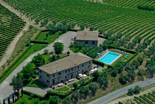 an aerial view of a house with a swimming pool and a vineyard at Agriturismo Macinatico in San Gimignano