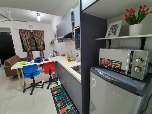 een kleine keuken met een tafel en een koelkast bij MyCozySOHO with Excellent Swimming Pool View in Cyberjaya