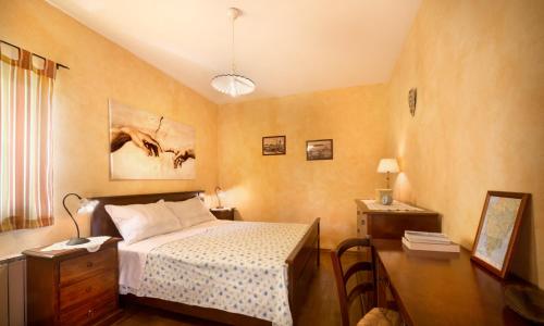 een slaapkamer met een bed en een bureau met een lamp bij Apartmani Hrelja in Labinci