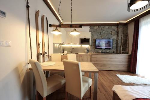 a kitchen and dining room with a table and chairs at 4Roses Apartments in Smokovce
