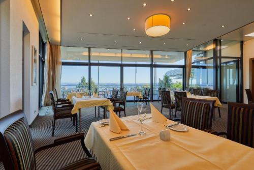 a restaurant with tables and chairs with a view at Parkhotel St.Leonhard in Überlingen