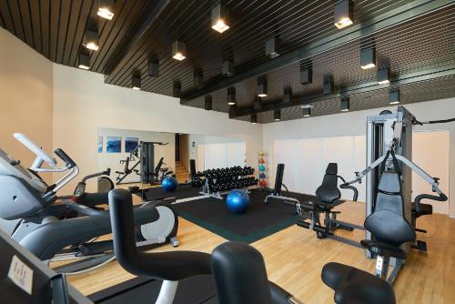 a gym with several treadmills and exercise bikes at Parkhotel St.Leonhard in Überlingen
