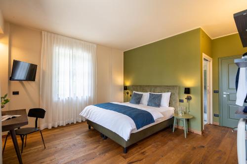 a bedroom with a bed and a desk and a television at Cascina Bo in Canelli
