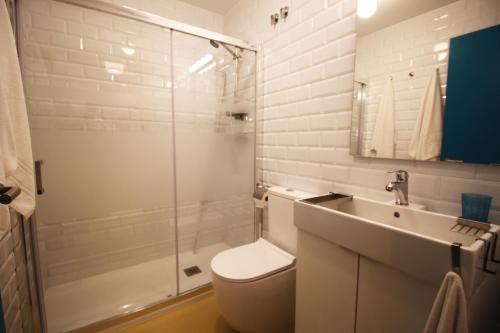 y baño con aseo, lavabo y ducha. en Apartamento Tipo Loft en Somo
