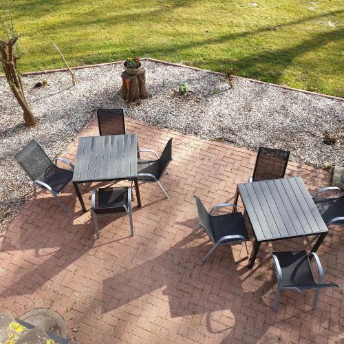 three wooden tables and chairs on a brick patio at Gästehaus Strudthoff in Ganderkesee