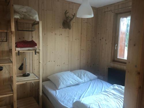 een kleine slaapkamer met een bed en een raam bij Vue Panoramique - 800m pistes Hohneck - Wifi - classé 3 étoiles in La Bresse