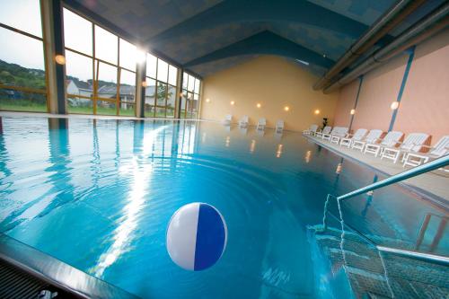 una piscina con una pelota en el agua en JUFA Hotel Vulkanland, en Gnas