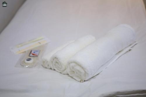 a pile of white towels on a bed at Guest House in Gyumri in Gyumri