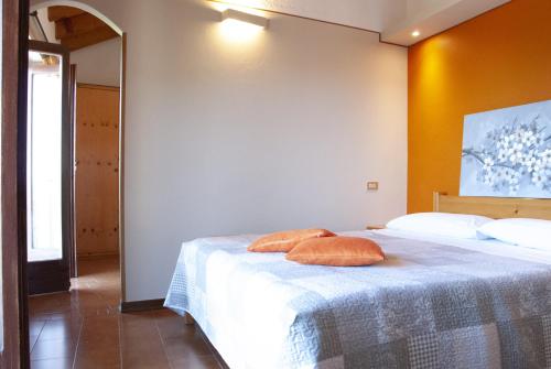 a bedroom with two orange pillows on a bed at Ristorante Bellavista con Locanda in Veleso
