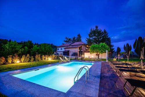 a swimming pool in front of a house at night at Cascina Bo in Canelli