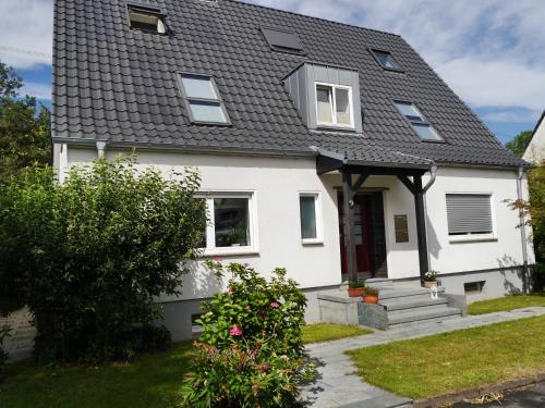 a white house with a black roof at FeWo BlumenPott in Dortmund