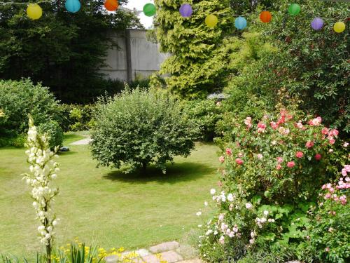 a garden with colorful balloons hanging from trees and flowers at FeWo BlumenPott in Dortmund