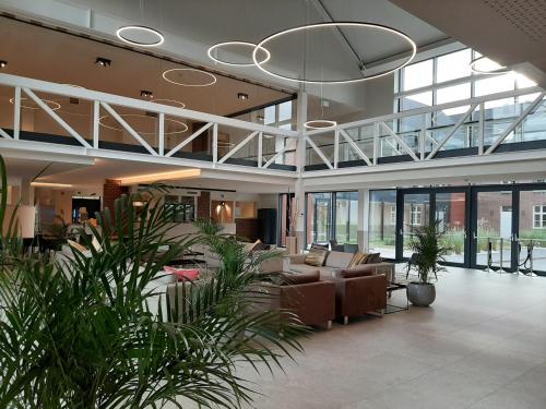 a lobby with couches and plants in a building at Hof van Stayen in Sint-Truiden