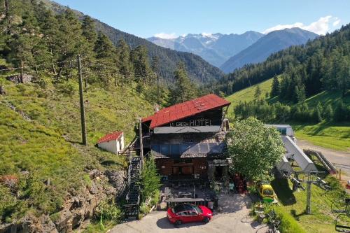 un pequeño edificio con techo rojo en una montaña en Green Ecolodge, en La Colmiane