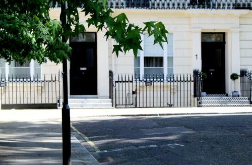 een gebouw met twee zwarte deuren in een straat bij 1 Craven Hill Gardens in Londen