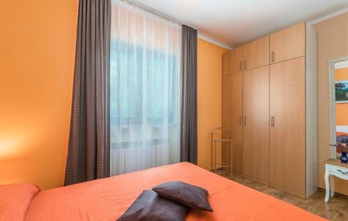 a bedroom with an orange bed and a window at Villa Antonela in Radetići