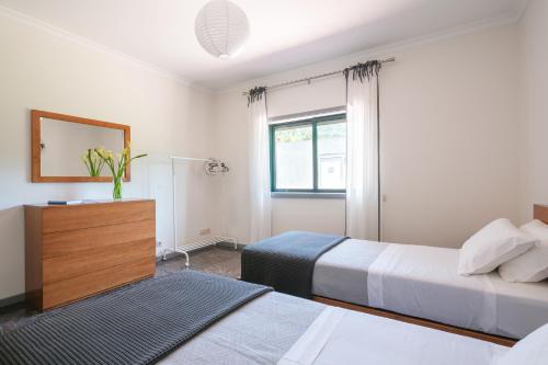 1 Schlafzimmer mit 2 Betten, einer Kommode und einem Fenster in der Unterkunft Stunning 3-bed-2-bath villa over Douro River;Porto city - WIFI-sleep 6-10 in Aveiro