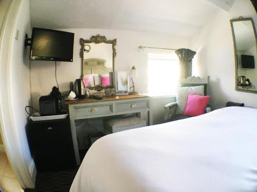 a bedroom with a bed and a dresser with a mirror at Hillside Bed and Breakfast in Crediton