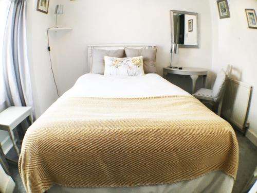 a bedroom with a large bed with a yellow blanket at Hillside Bed and Breakfast in Crediton
