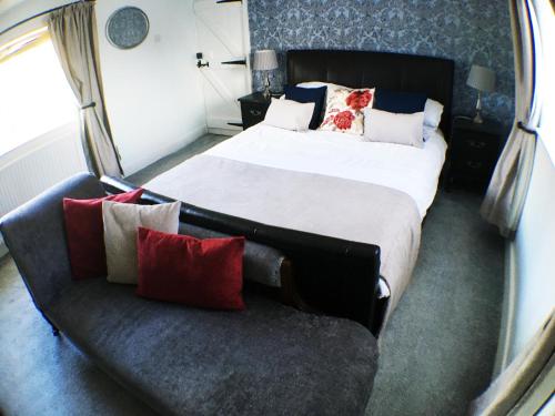 a bedroom with a bed and a couch with pillows at Hillside Bed and Breakfast in Crediton