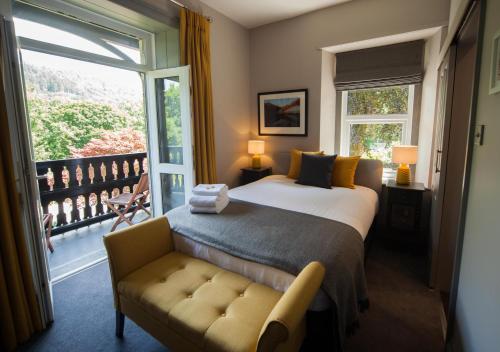 a bedroom with a bed and a window and a couch at Mary's Court Guest House - Mairlys in Betws-y-coed