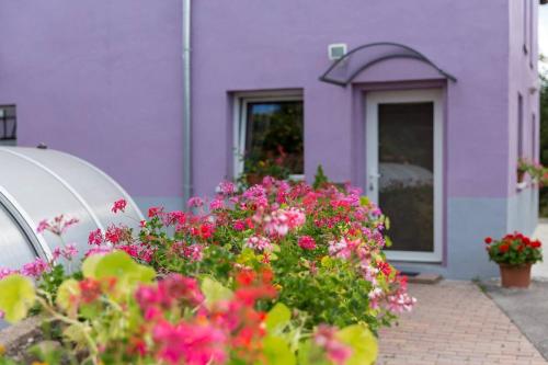 a purple house with flowers in front of it at Les Jardins de Lo're'an in Holtzwihr