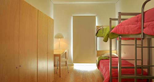 a bedroom with two bunk beds and a desk at Azores Youth Hostels - Santa Maria in Vila do Porto