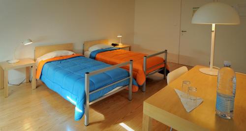 Un dormitorio con 2 camas y una mesa con una mesa. en Azores Youth Hostels - Santa Maria, en Vila do Porto