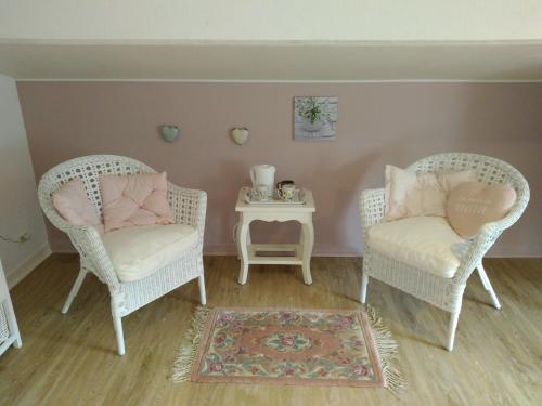 two chairs and a side table in a room at Au Cœur de Ménestérol Chambre Émotion in Montpon-Ménestérol