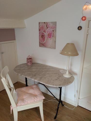 a table with a lamp and a chair and a table with a lamp at Au Cœur de Ménestérol Chambre Émotion in Montpon-Ménestérol