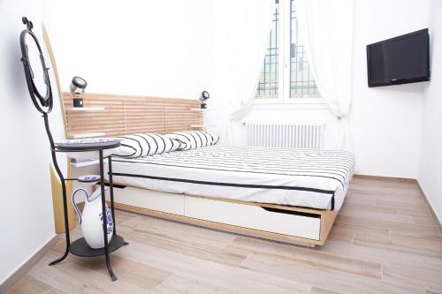 a bedroom with two beds and a tv on a wall at La MaGiA di Villa in Villanova