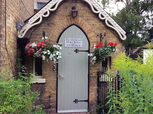 a door in a brick building with a sign on it at The Old School House Rooms in Waterbeach