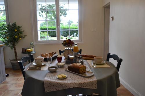 una mesa con un mantel con un pastel. en Au Cœur de Ménestérol Chambre Émotion, en Montpon-Ménestérol