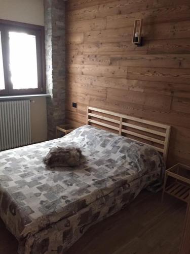 una camera con un letto su una parete in legno di Saint Patrick's INN a Limone Piemonte