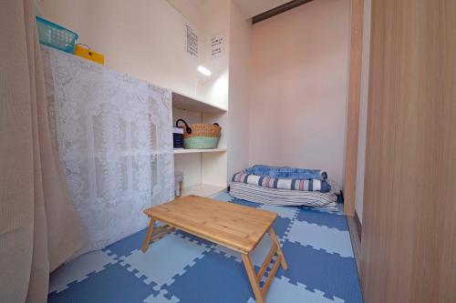 越谷市にあるタローズホステル南越谷のテーブルとベッド付きの小さな部屋