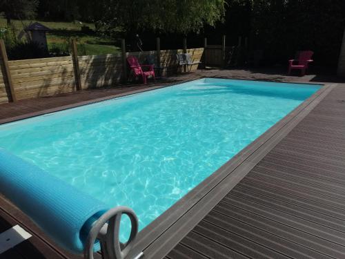 uma piscina com água azul num quintal em patrice et chrstel Appartement indépendant em Les Malossannes