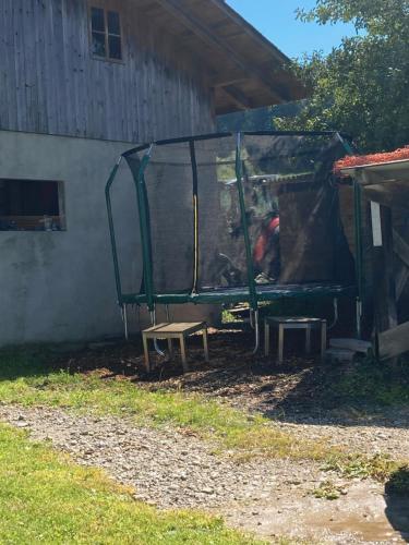 a man sitting in a batting cage with a bench at Eggelried, wo die Natur zu Hause ist.. in Emmenmatt