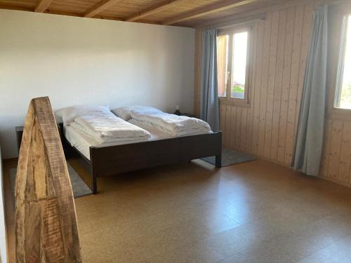 a bedroom with a bed in a room with a window at Eggelried, wo die Natur zu Hause ist.. in Emmenmatt