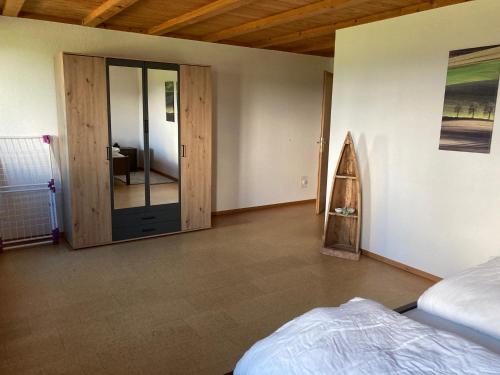 a bedroom with a bed and a sliding glass door at Eggelried, wo die Natur zu Hause ist.. in Emmenmatt