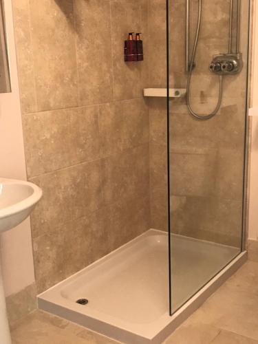 a shower with a glass door in a bathroom at The Old School House Rooms in Waterbeach