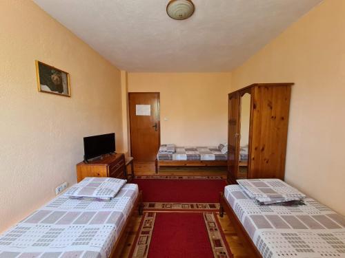 a room with two beds and a tv in it at Villa Mura in Razlog