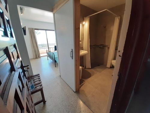 a hallway with a bathroom with a shower and a door at Hotel Buenavista in Estepona