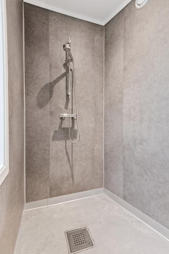 a shower with a hose on a wall at Aalesund City Apartment in Ålesund